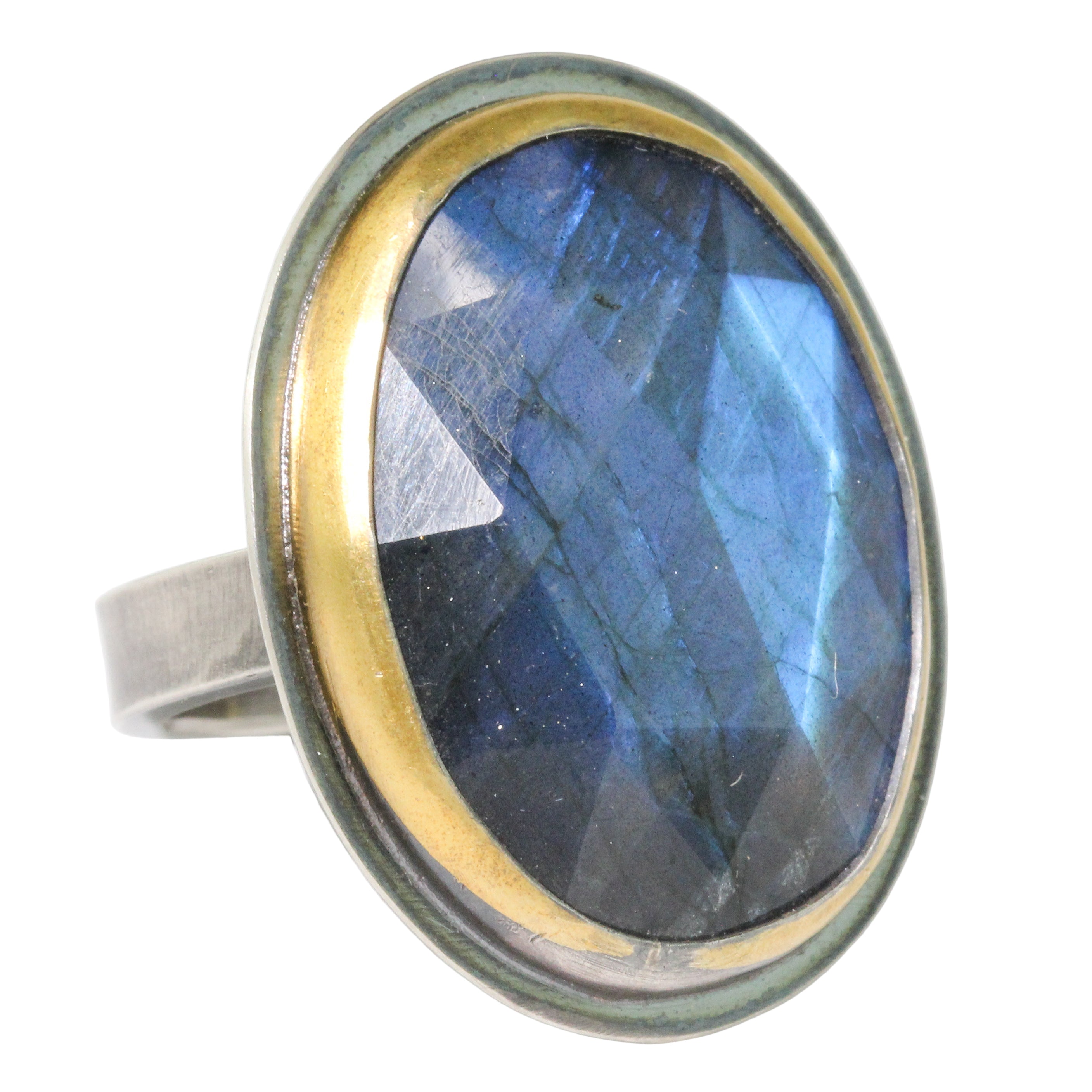 Ring with blue gemstone and gold and silver band on a white background