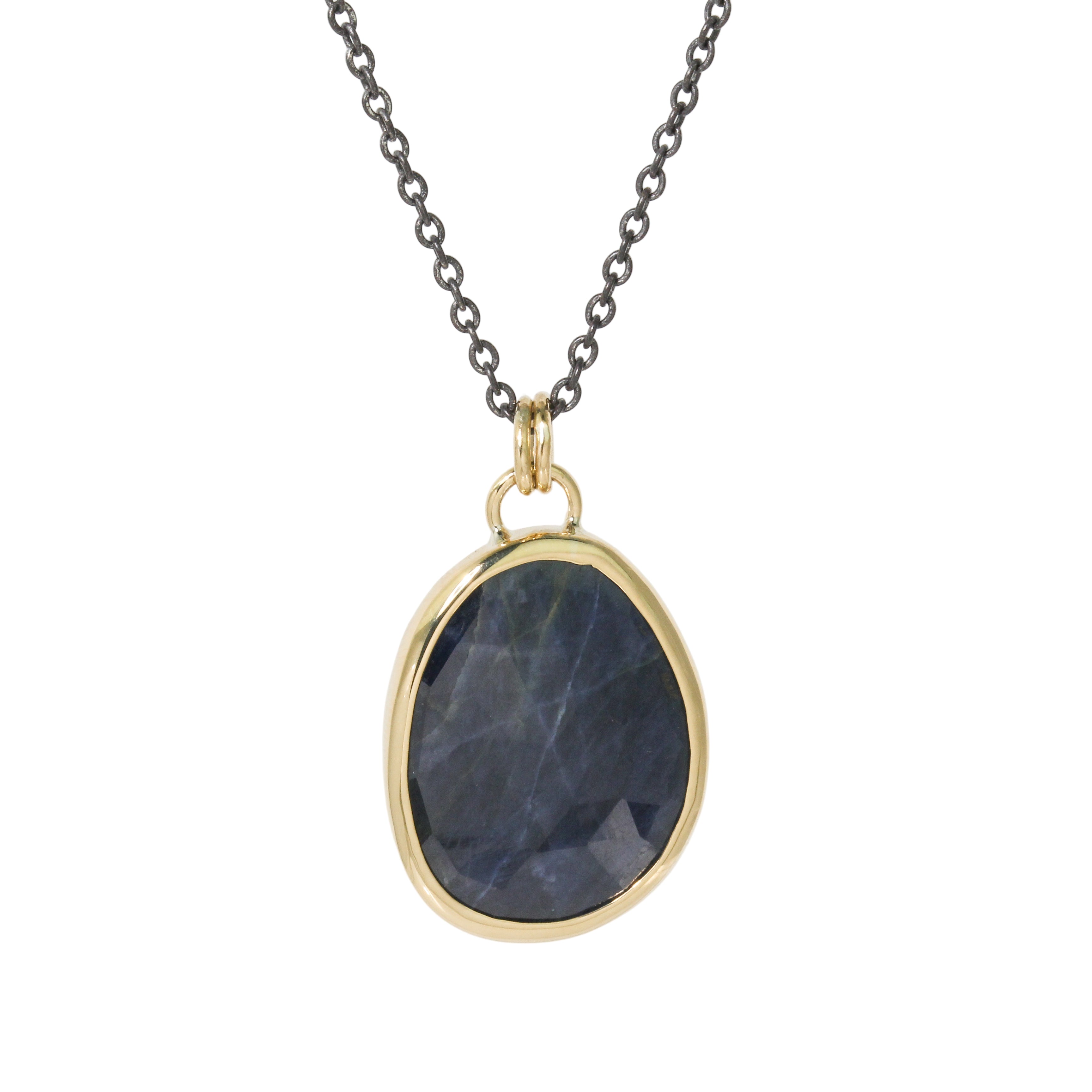 Necklace with a gold pendant featuring a sapphire stone on a white background