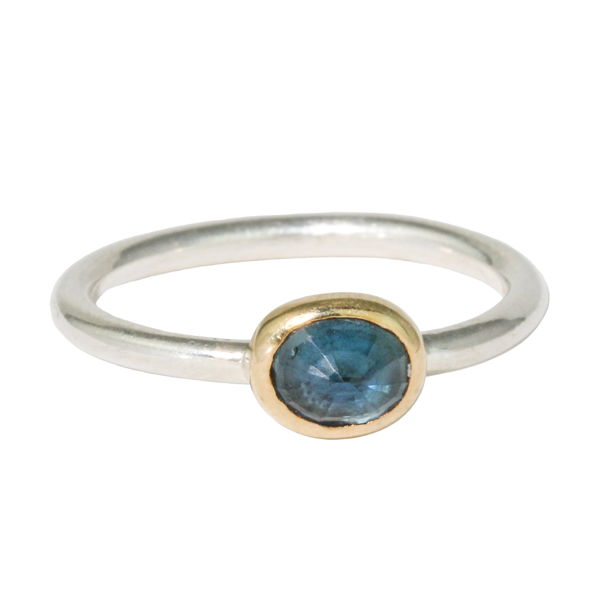 Silver ring with a gold bezel and blue gemstone on a white background