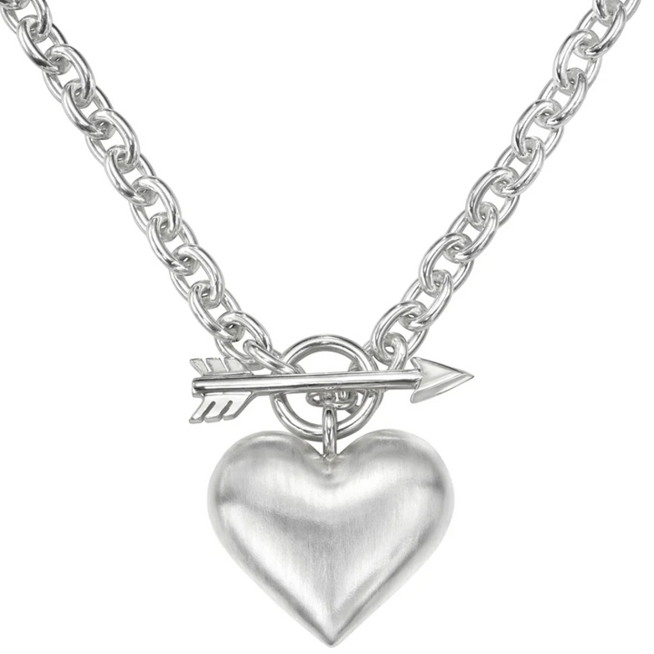 Silver necklace with a heart pendant and arrow charm on a white background