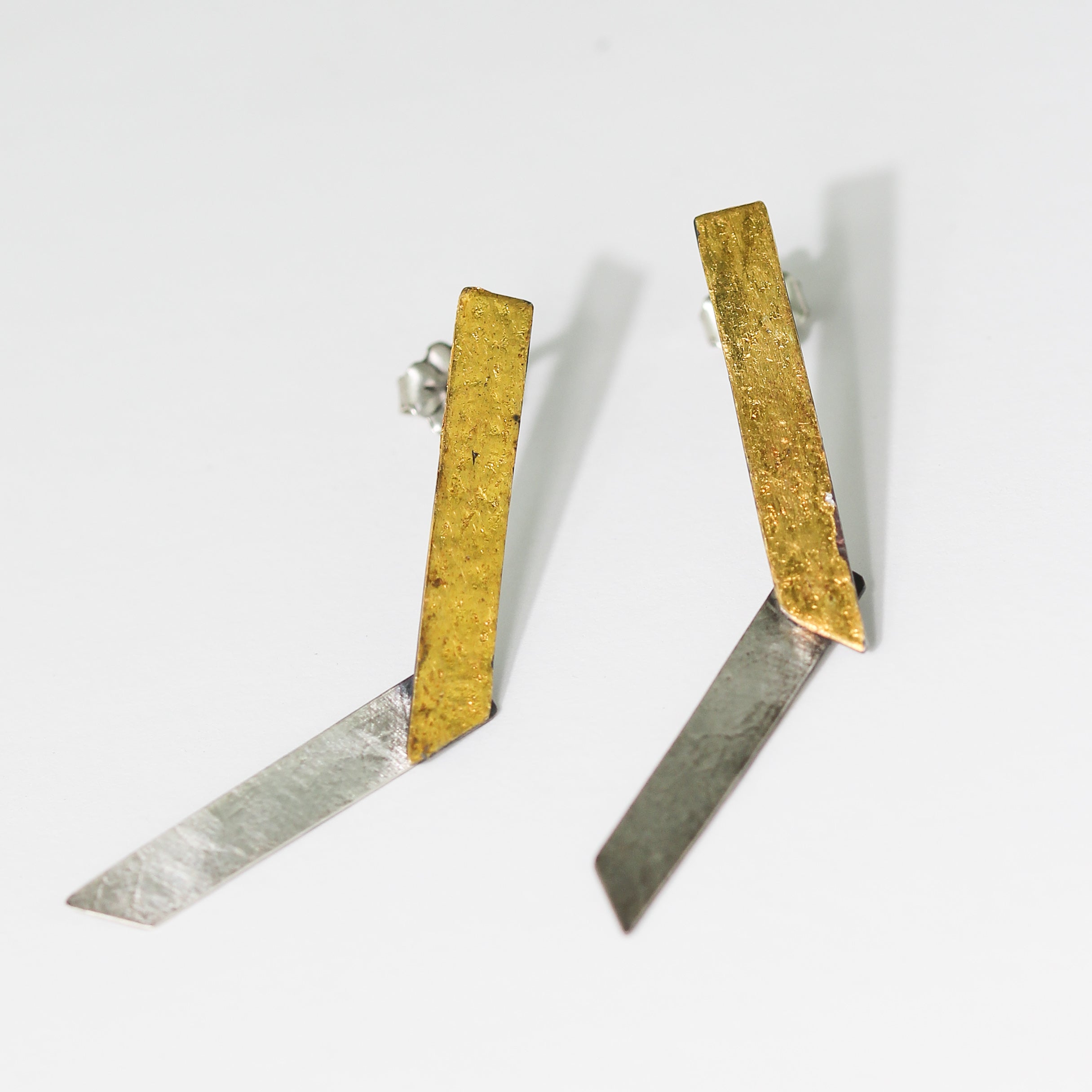 Pair of earrings with gold and silver rectangular designs on a white background