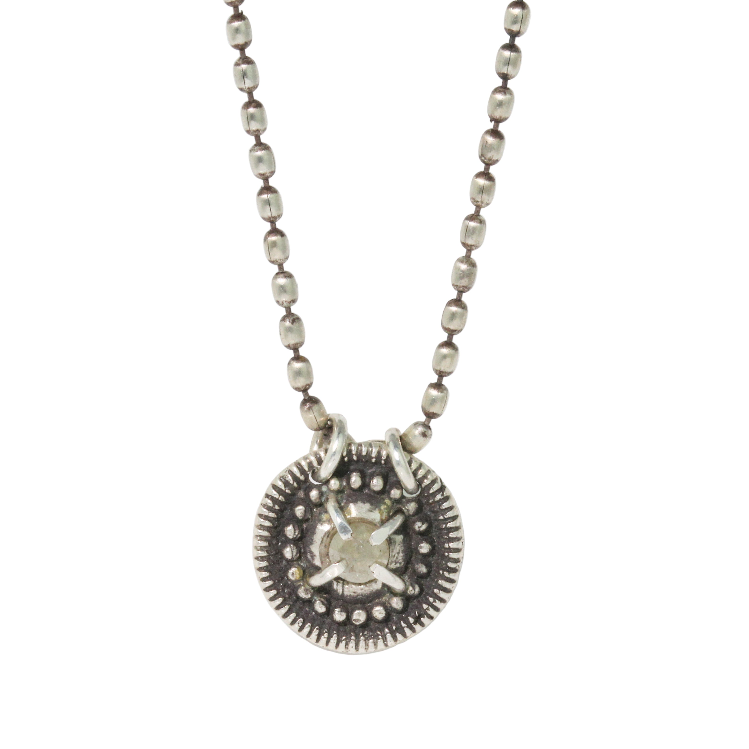 Silver necklace with a round pendant on a white background